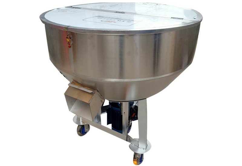 A large stainless steel feed mixer in action, blending various powdered materials.